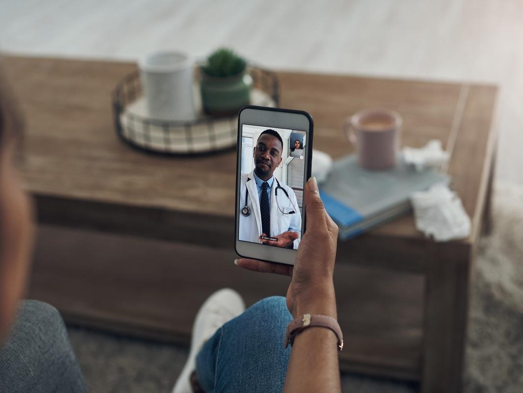Shot of an unrecognizable person on a videocall with a doctor