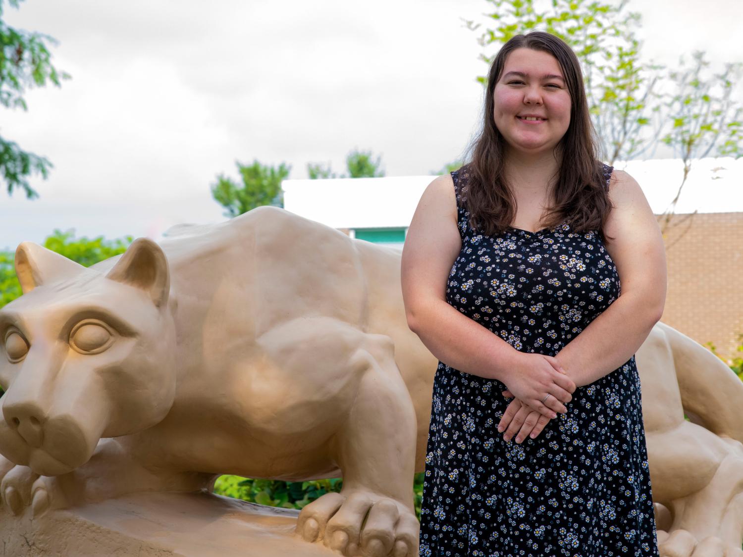 Olivia Spotto posing in front of the Penn State Fayette lion shrine.