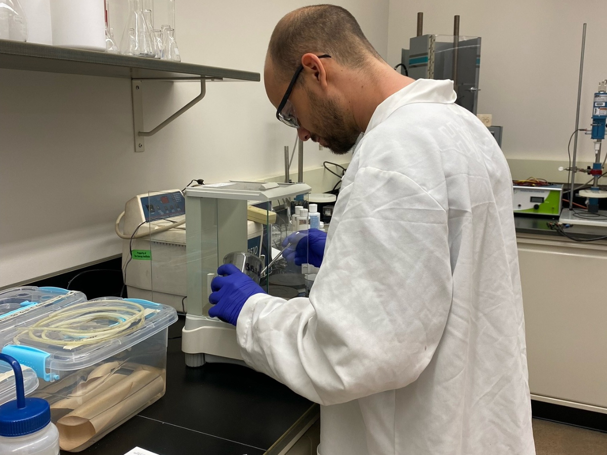 Domenic Contrino working in a lab wearing a lab coat
