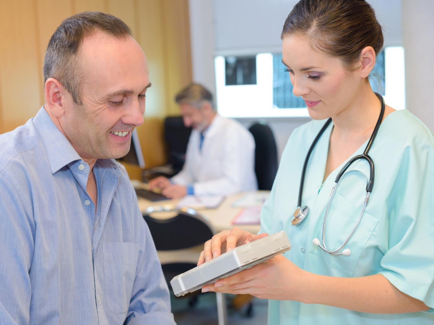 A medical assistant gets information from a patient.