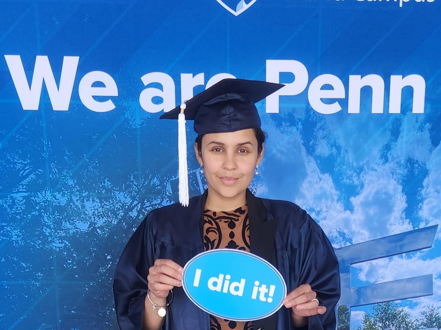 A woman stands in front of a Penn State-themed background.