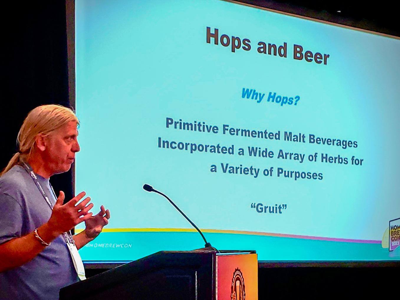 Timothy Yarrington presents at a podium with a slide show presentation behind him