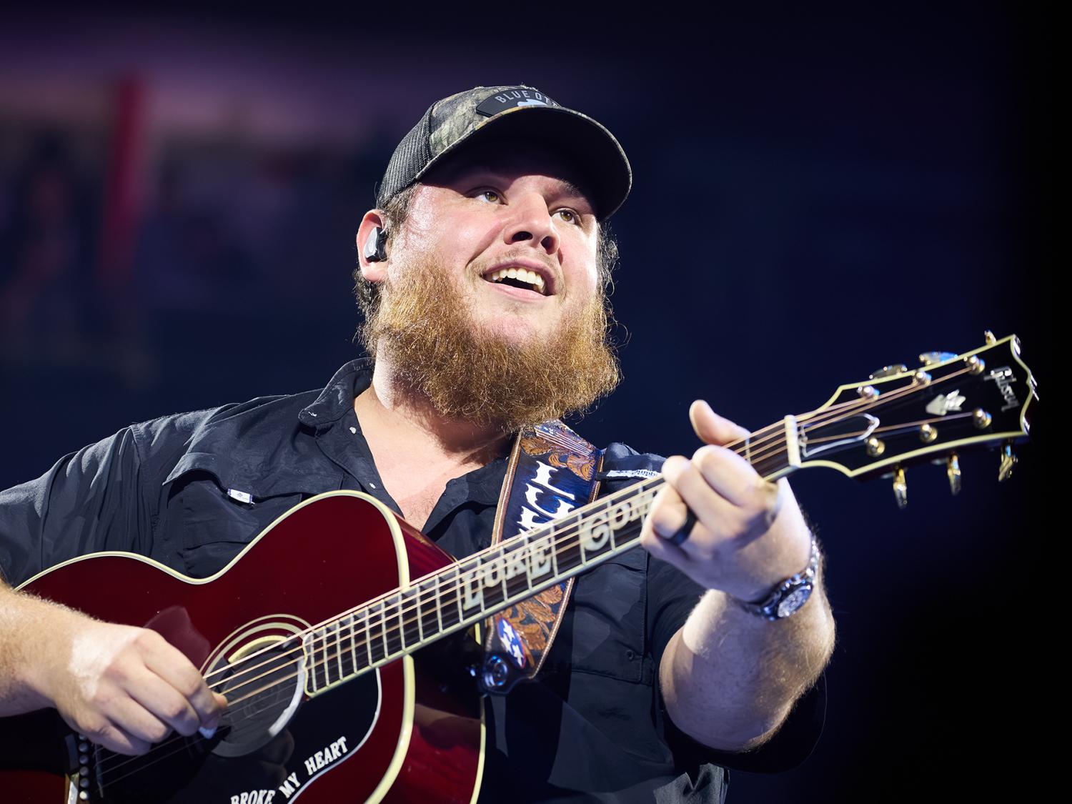 Luke Combs playing guitar and singing.