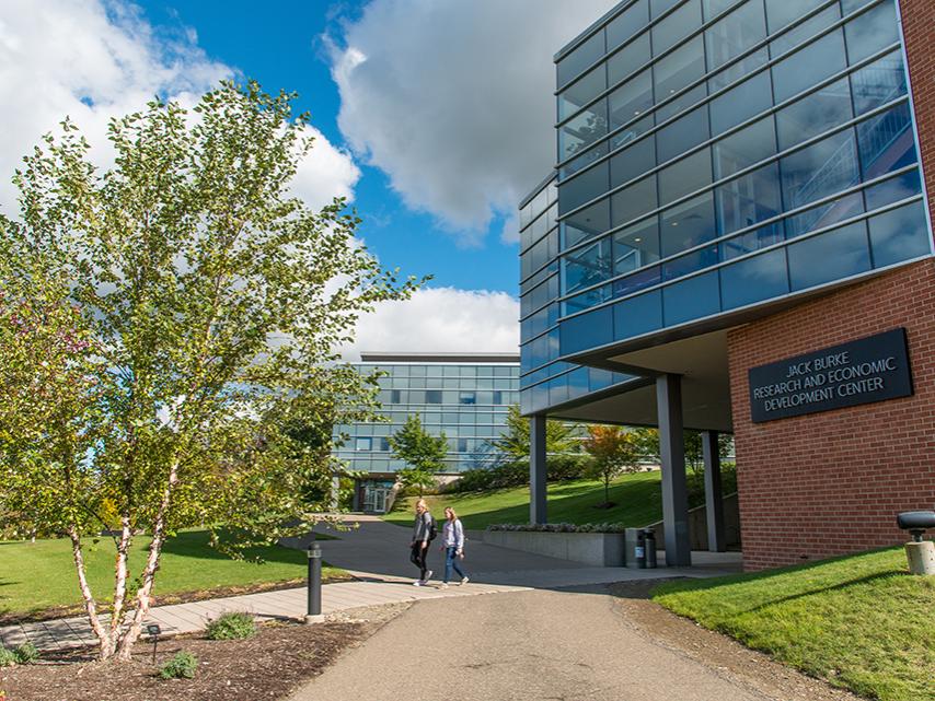 Two students walk in front of the Burke Center at Penn State Behrend.