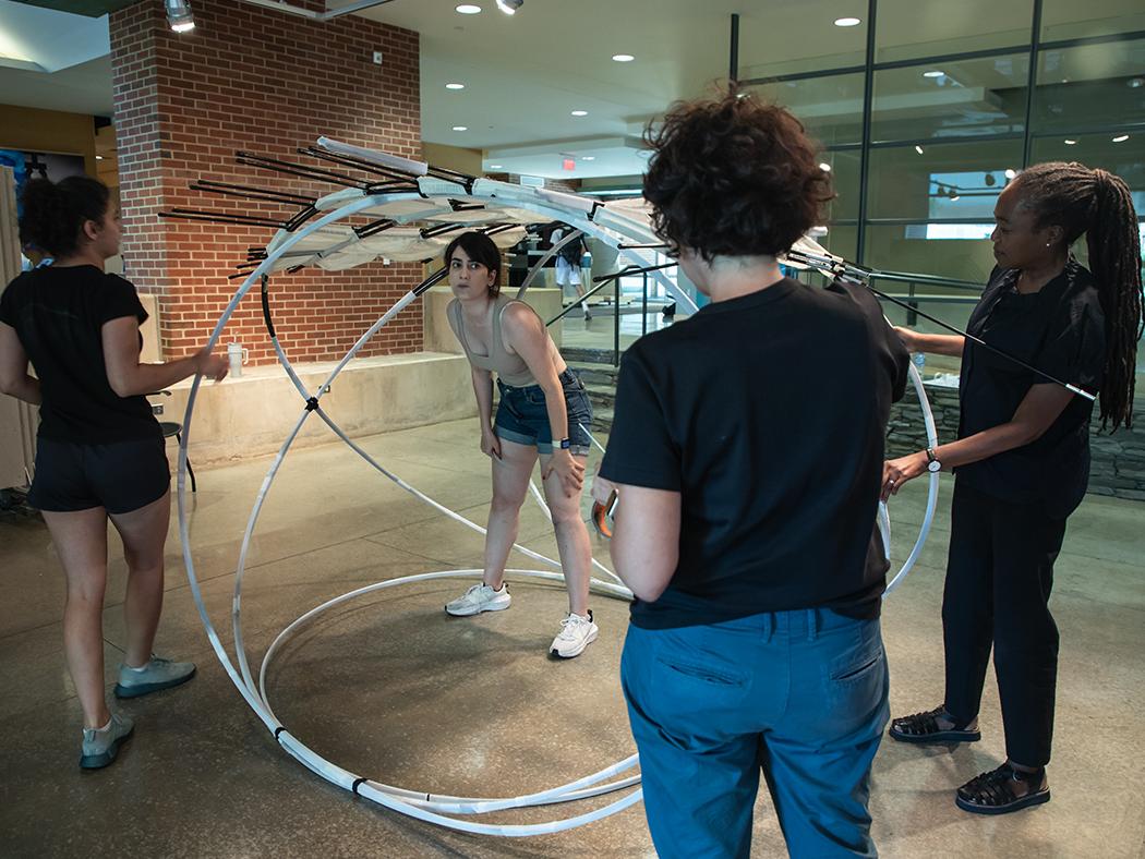 Felecia Davis, at right, and Benay Gürsoy work with two architecture doctoral students on a research prototype.