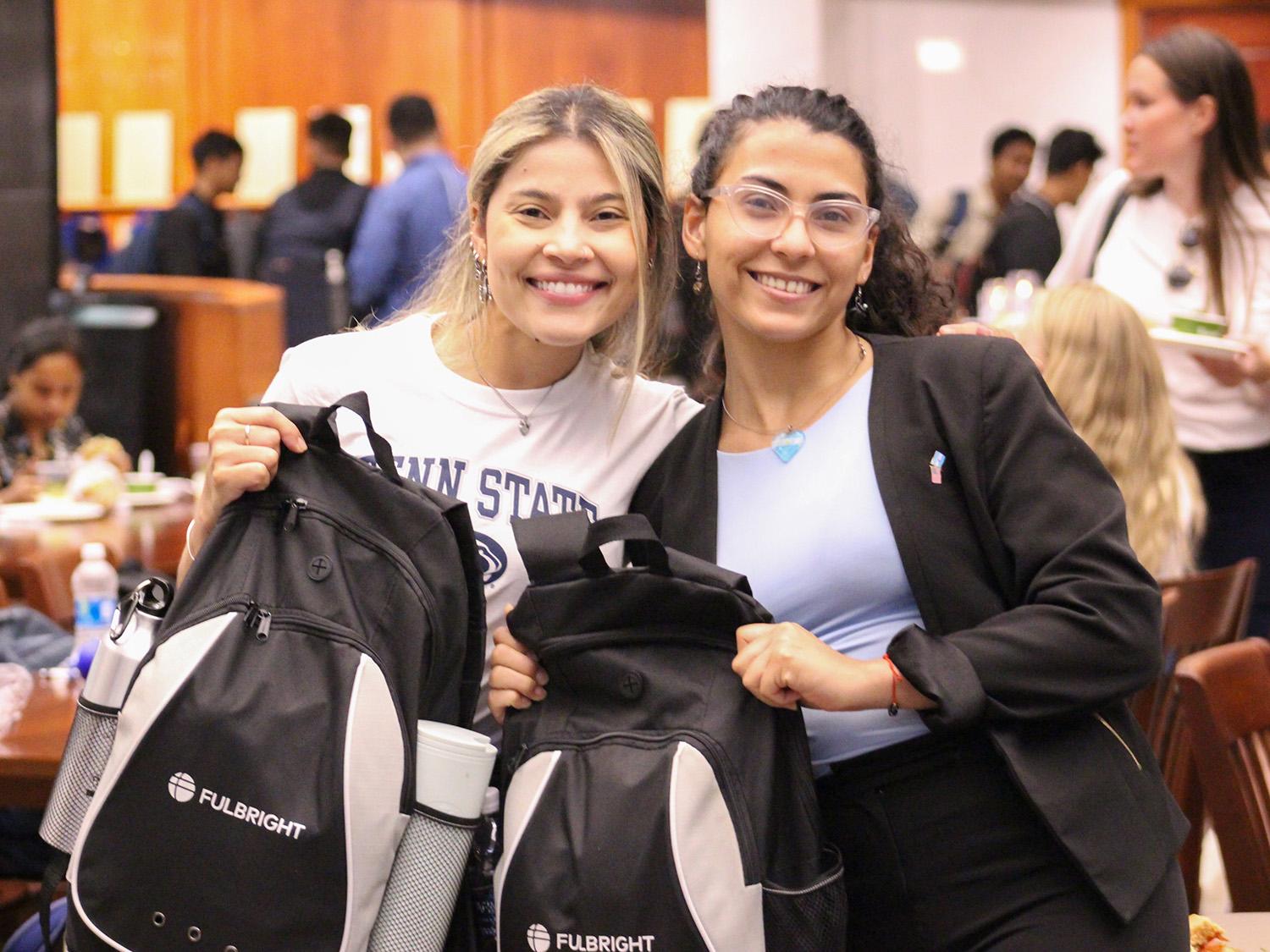 two students holding Fulbright backpacks