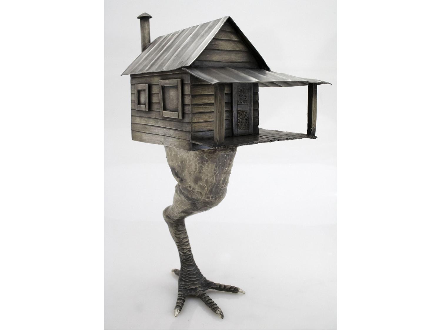 Artwork by Woodle, a cabin style house standing on a chicken leg