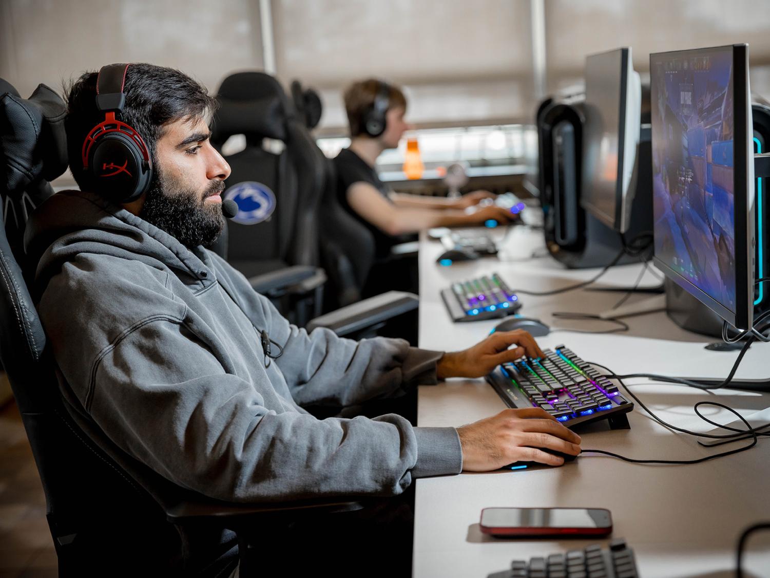 A male student plays a videogame in Penn State Behrend's esports lounge.