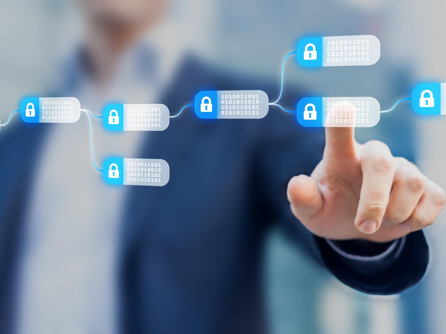 person in background uses finger to tap blockchain screen in foreground