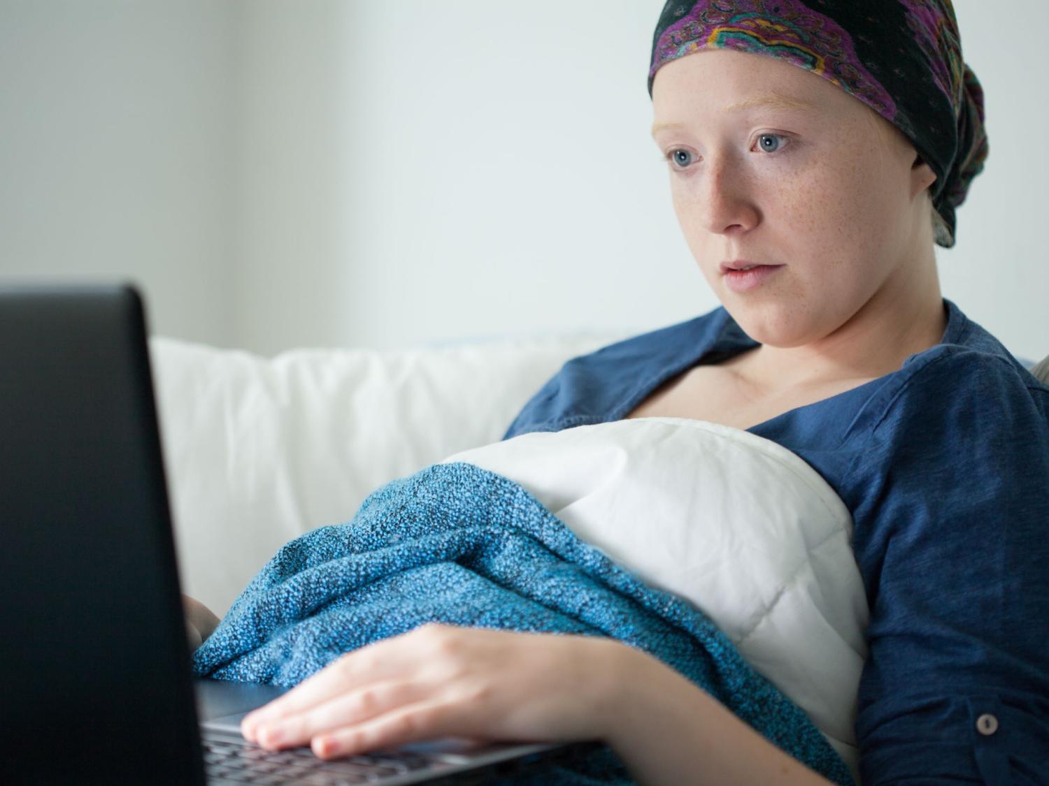 cancer patient browses laptop computer