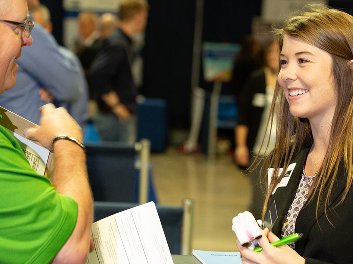 Two people talk at career day