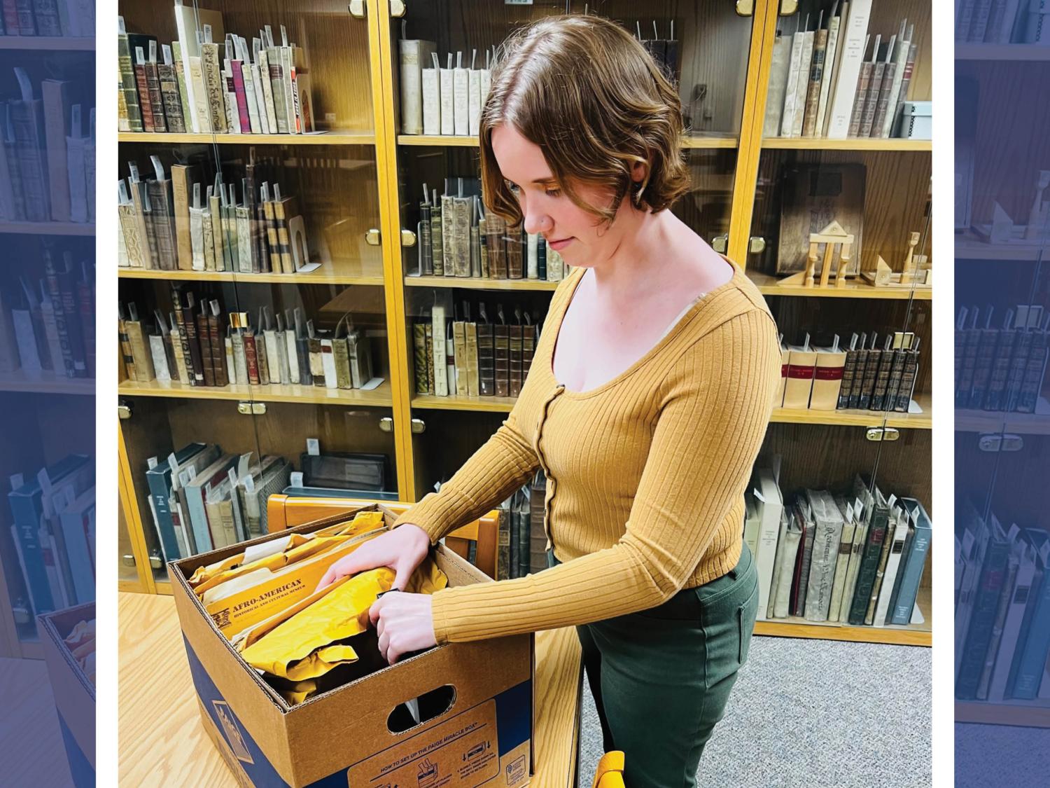 Cassandra Florian removing archival papers from box in library