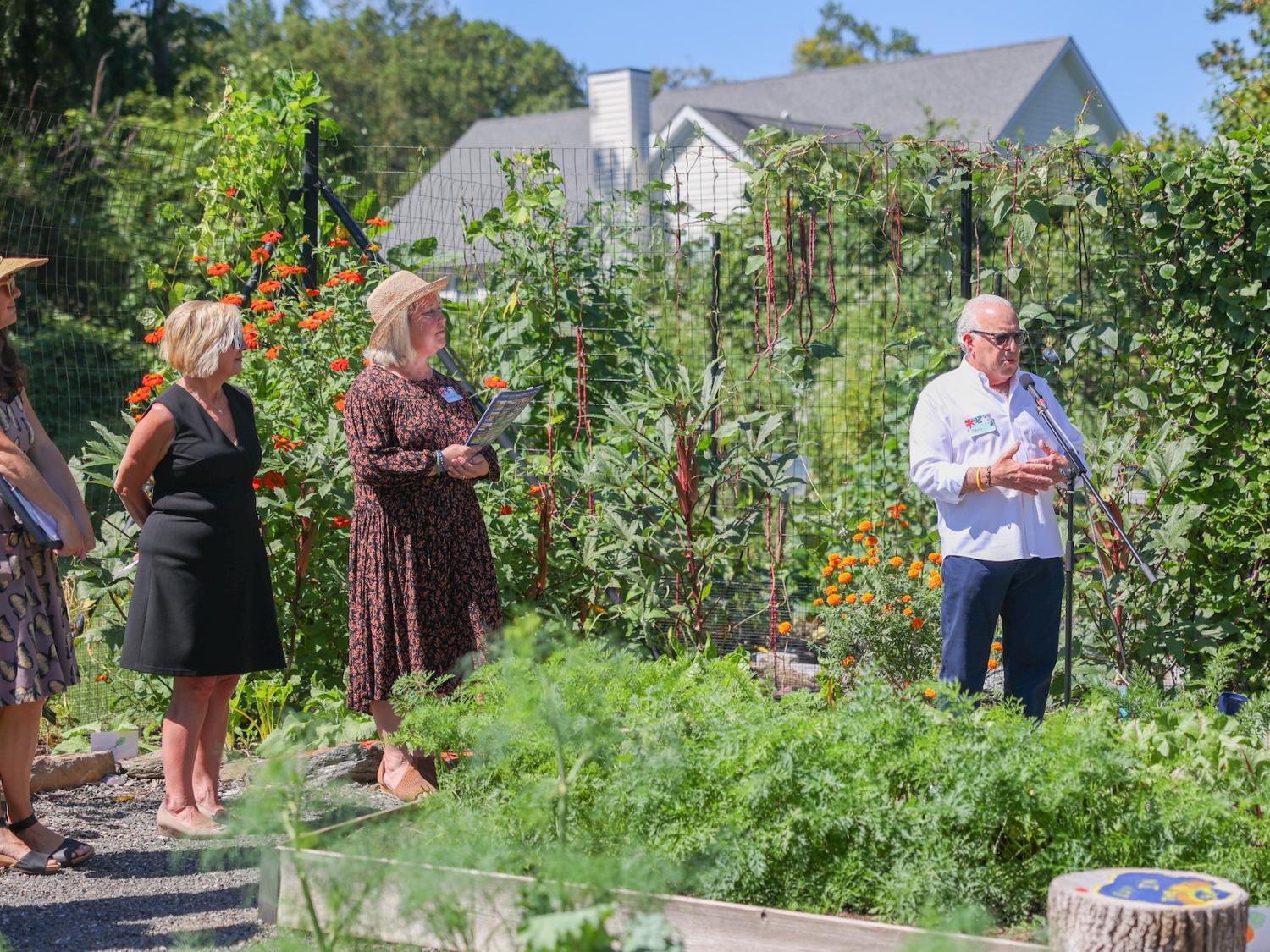 man speaking at microphone in garden