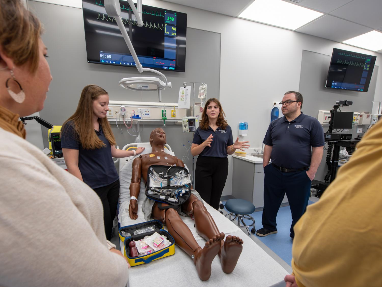 Penn College students in the college's Emergency Medicine Lab with a manikin that serves as a patient simulator