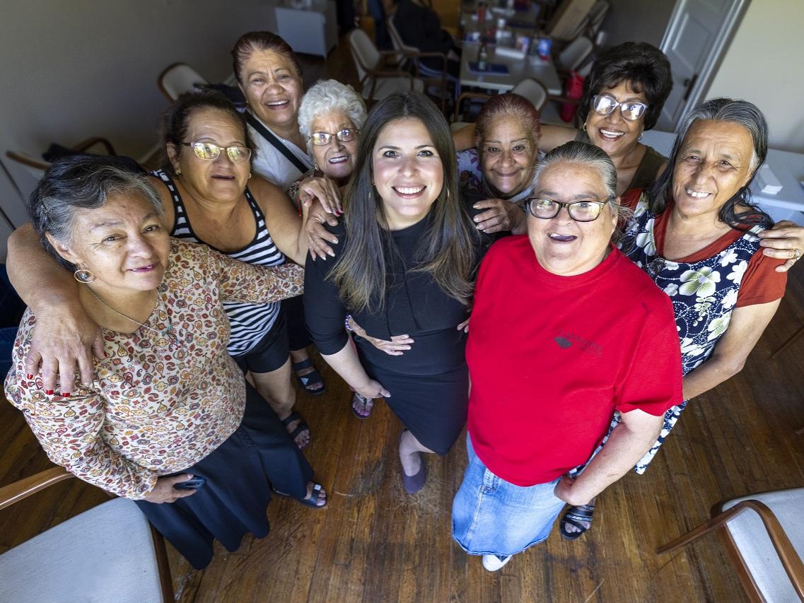Nine women stand together in a group photo. 