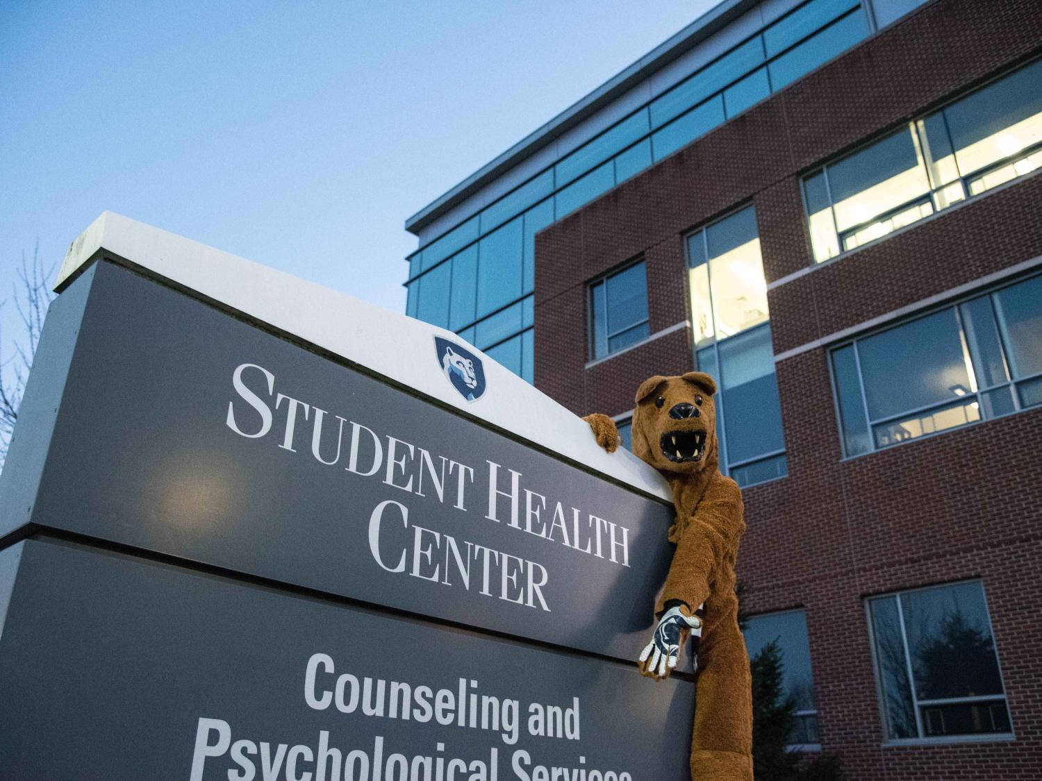 Nittany Lion posing in front of the Student Health Center sign