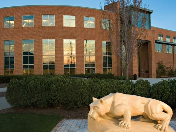 exterior of two-story brick building rounded on one side with tall thin glass windows