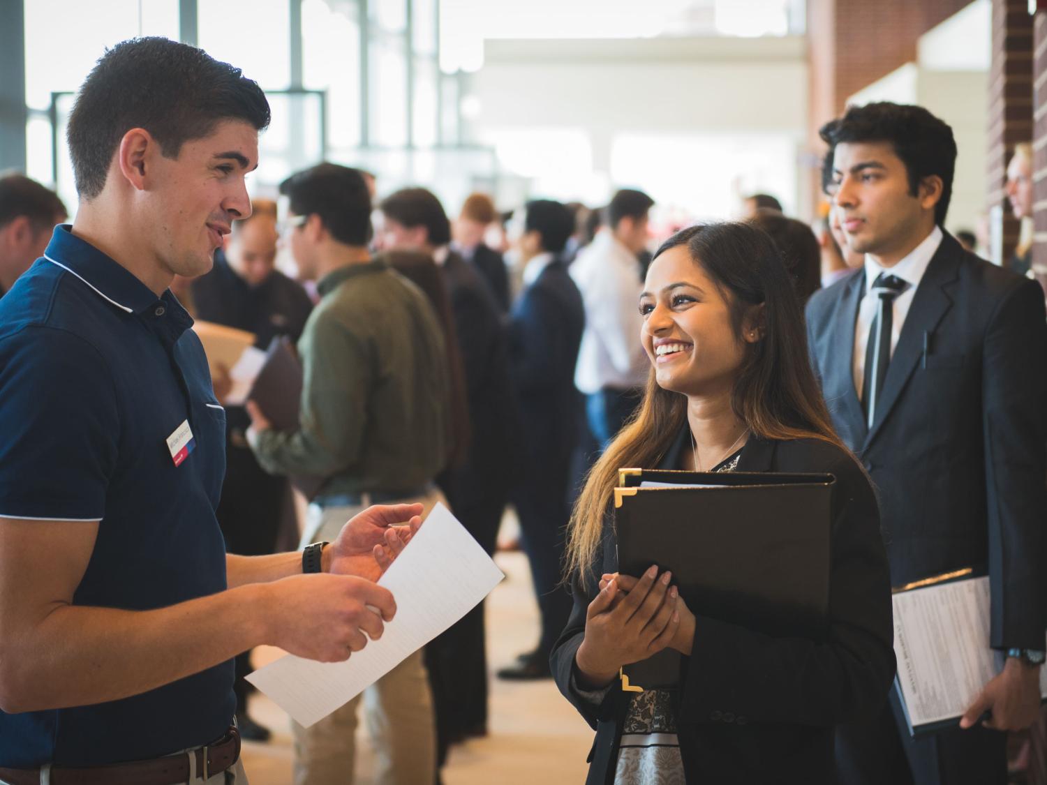 Students and employers talking at a career fair.