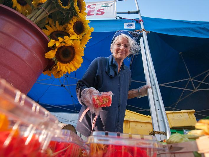 Person setting up a farmer's market stand.