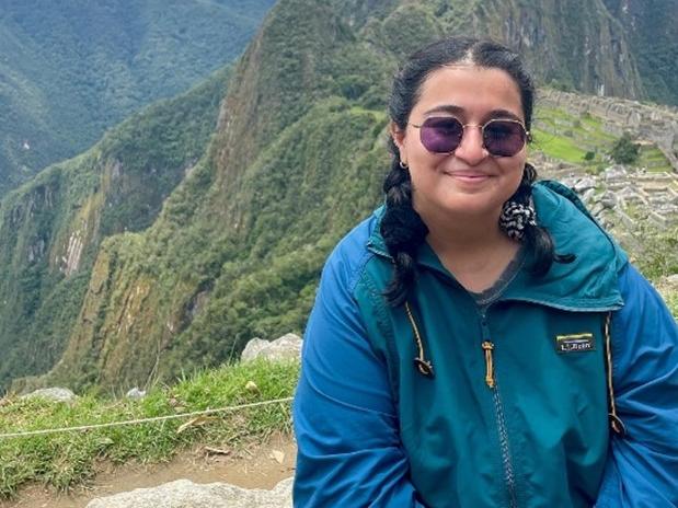 A young woman sitting in front of Machu Picchu