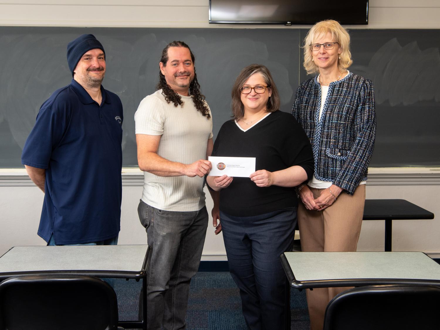 Four people and a check presentation