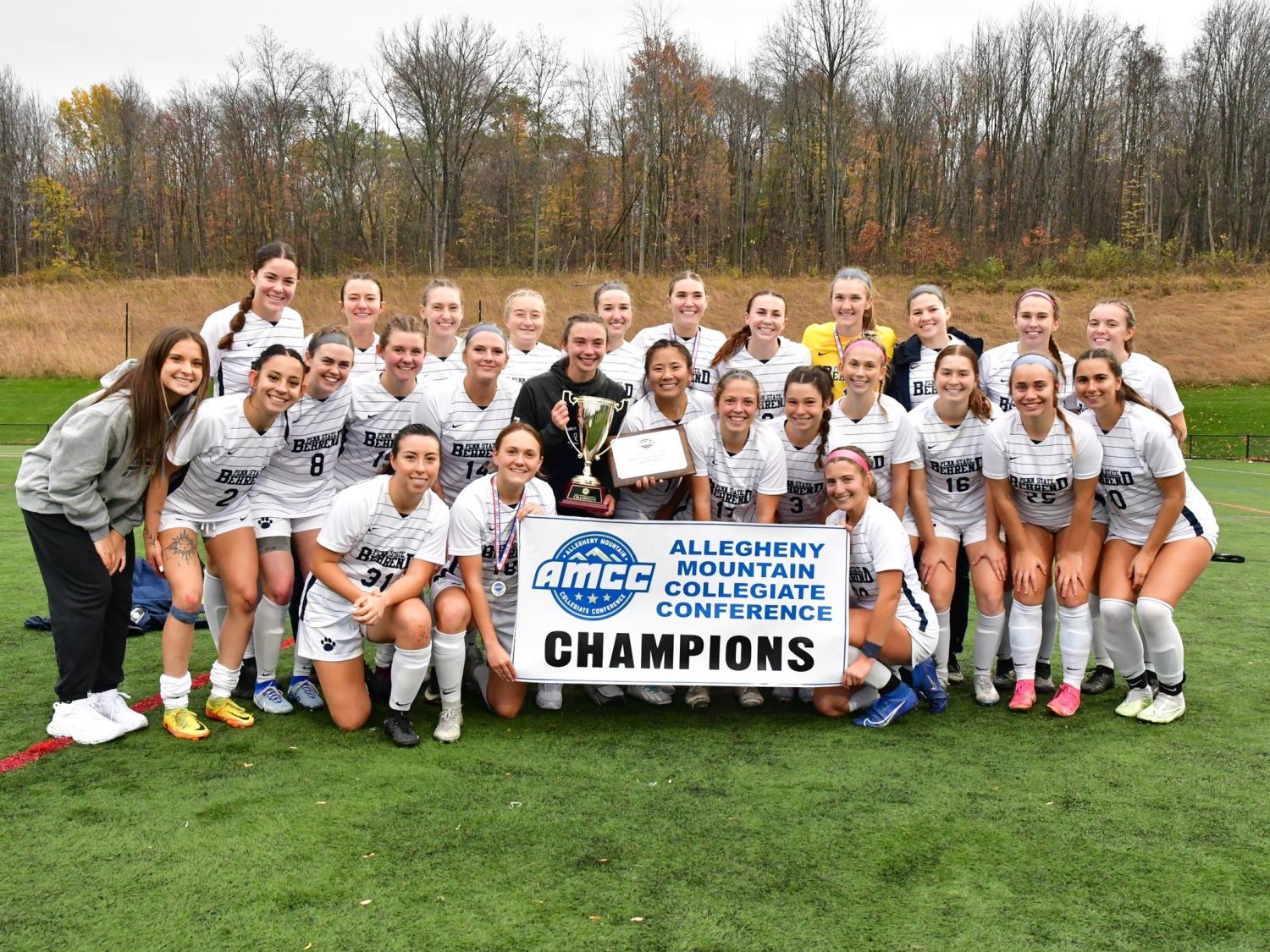 The Penn State Behrend women's soccer team poses with the AMCC championship banner.