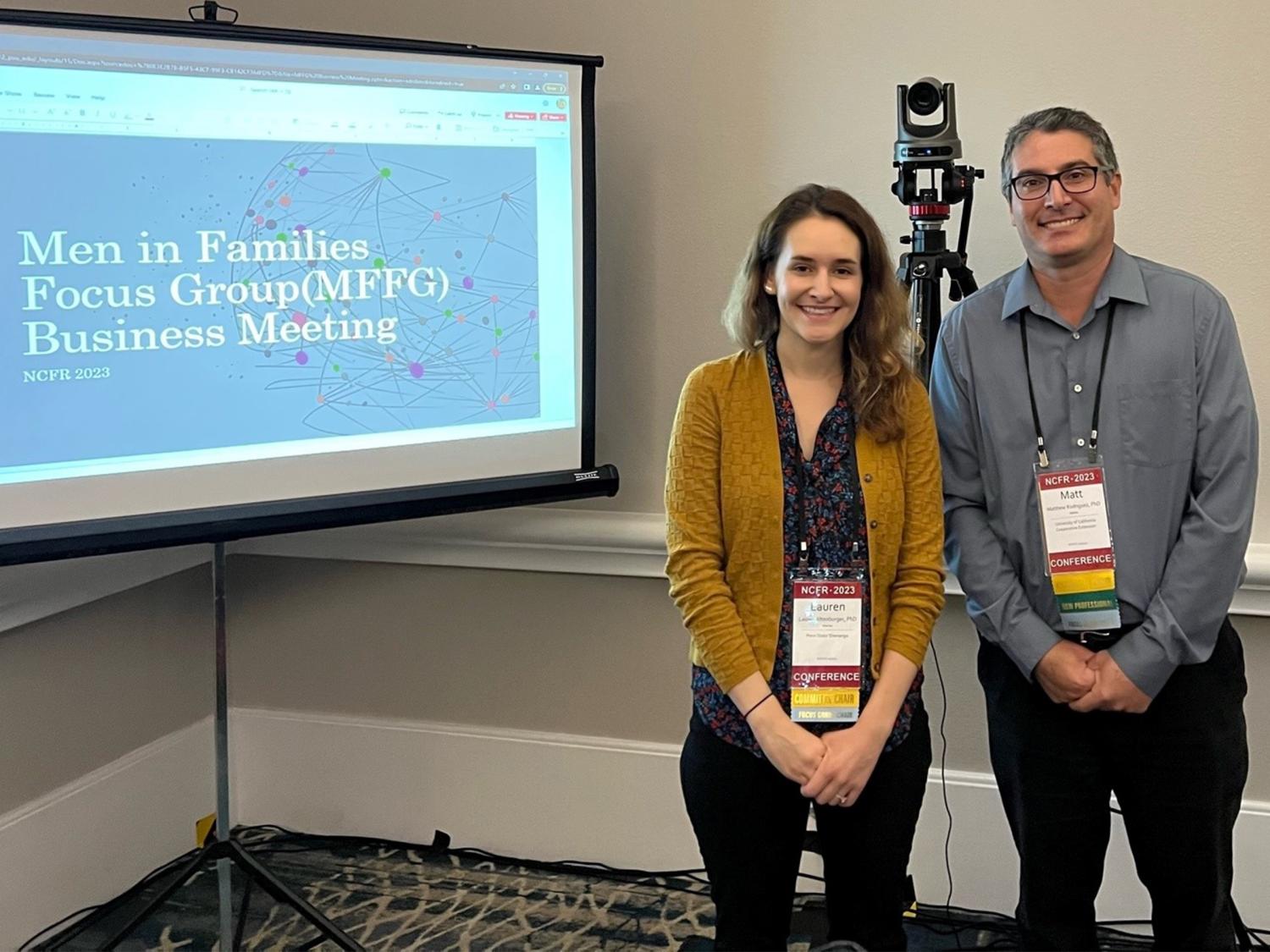 Lauren Altenburger stands with Dr. Matthew Rodriguez in front of a powerpoint presentation