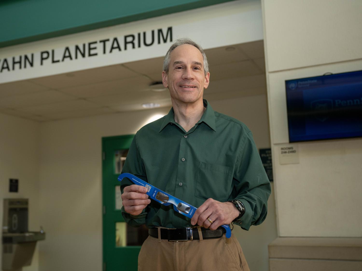 Planetarium director Jim Gavio holds a pair of eclipse glasses.