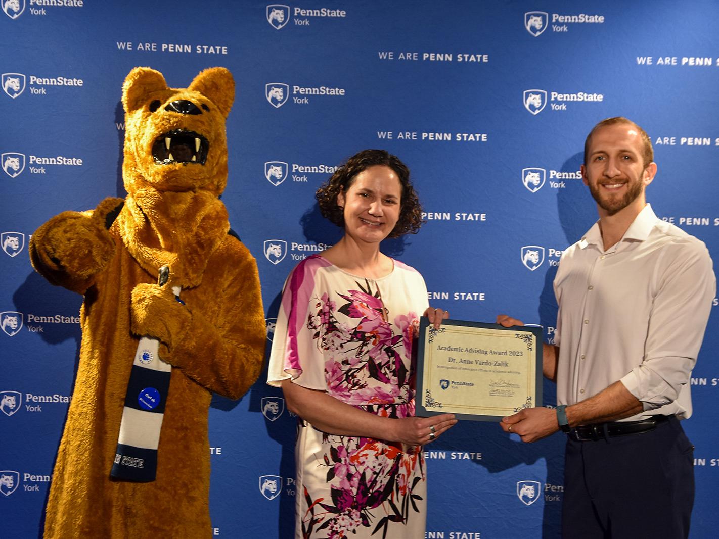 Nittany Lion characters, and a female and male fculty member hold a certificate