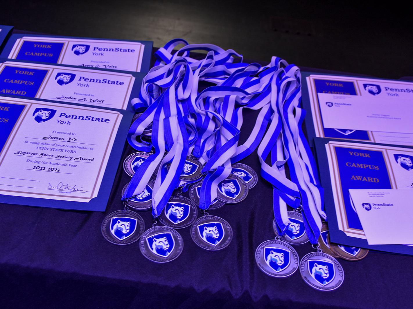 Certificates and award medallions on a table