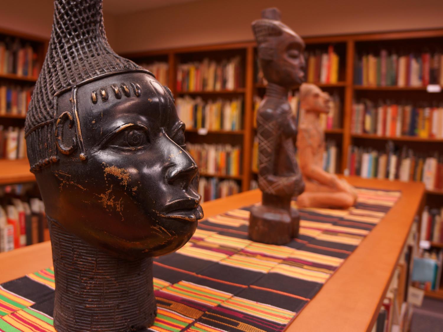 A variety of busts and small statues sit on top of bookshelves