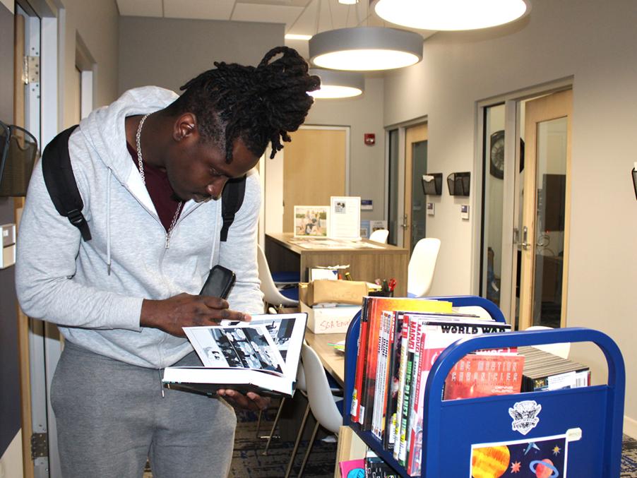 Student Jermin Gilbert browses through some of the selections on the science fiction themed library cart.