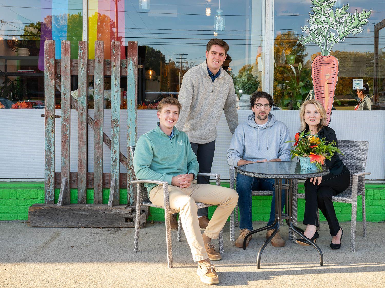 Three Penn State Behrend students pose with the owner of a local cafe.