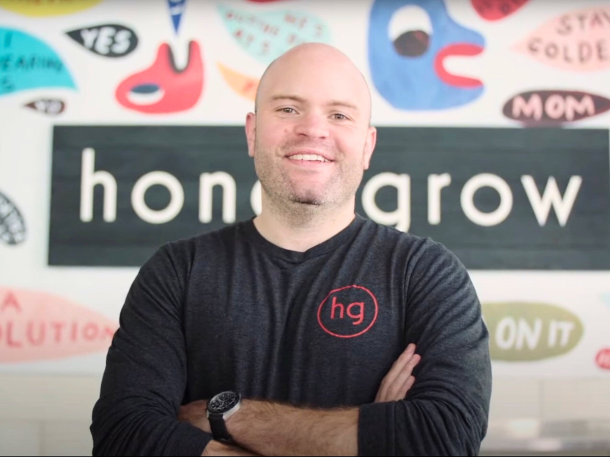 Justin Rosenberg stands in front of honeygrow mural