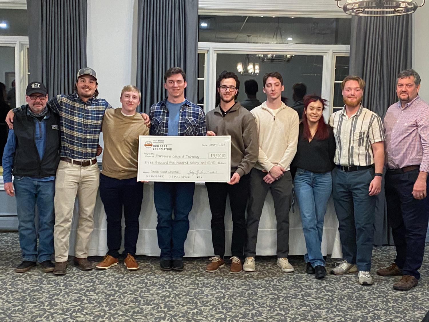 A group of people stand together from the Penn College Construction Association