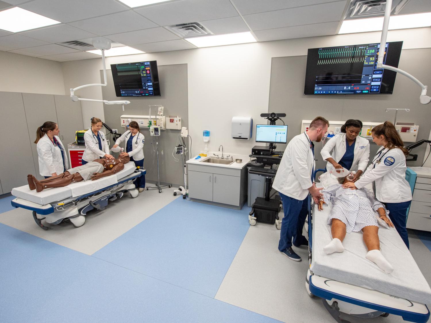 Several students work in a mock emergency department
