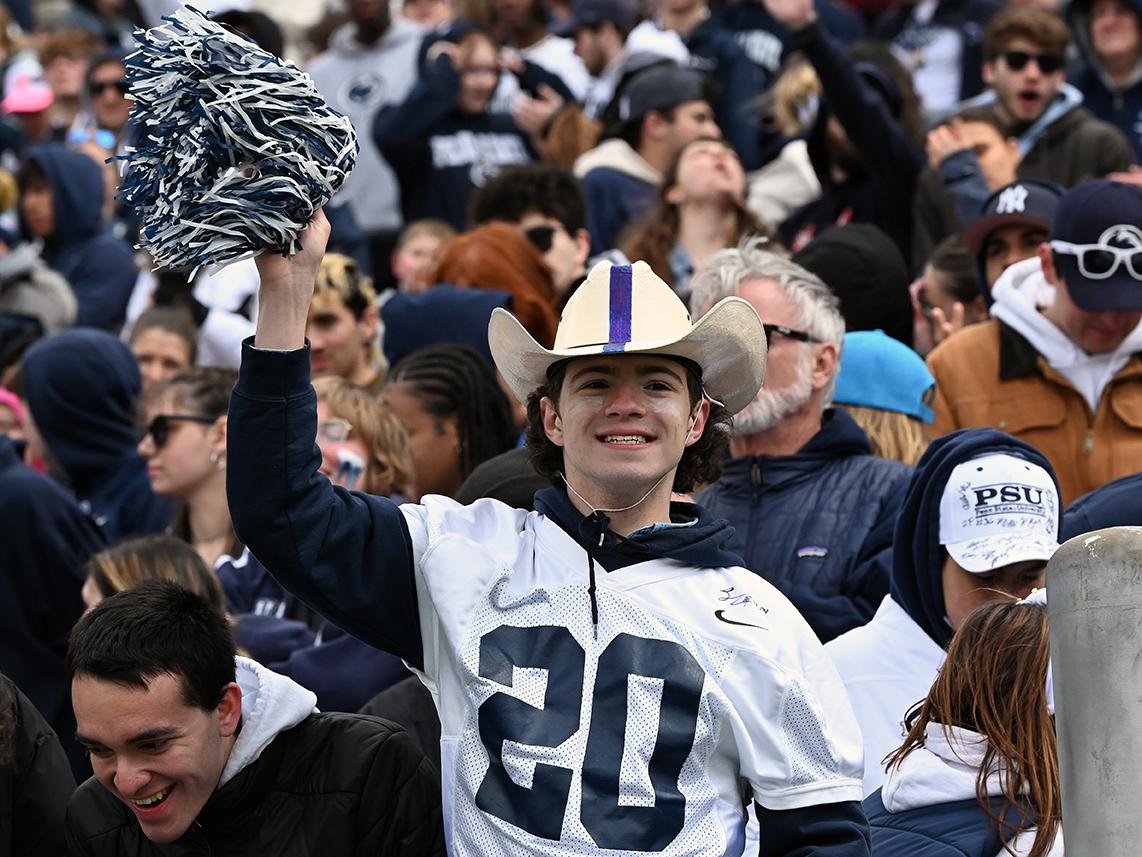 Male fan wearing cowboy hat cheers