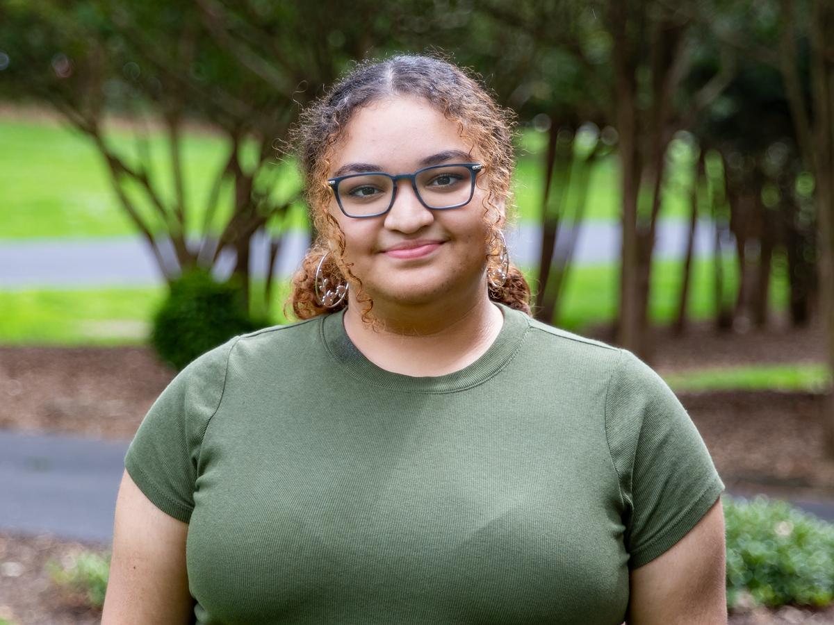 Student soloist Malinda Garcia wearing olive green t-shirt.