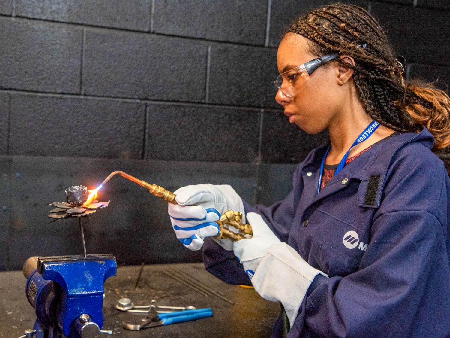 A participant in 2023’s Tinker Camp works diligently on a creative welding project