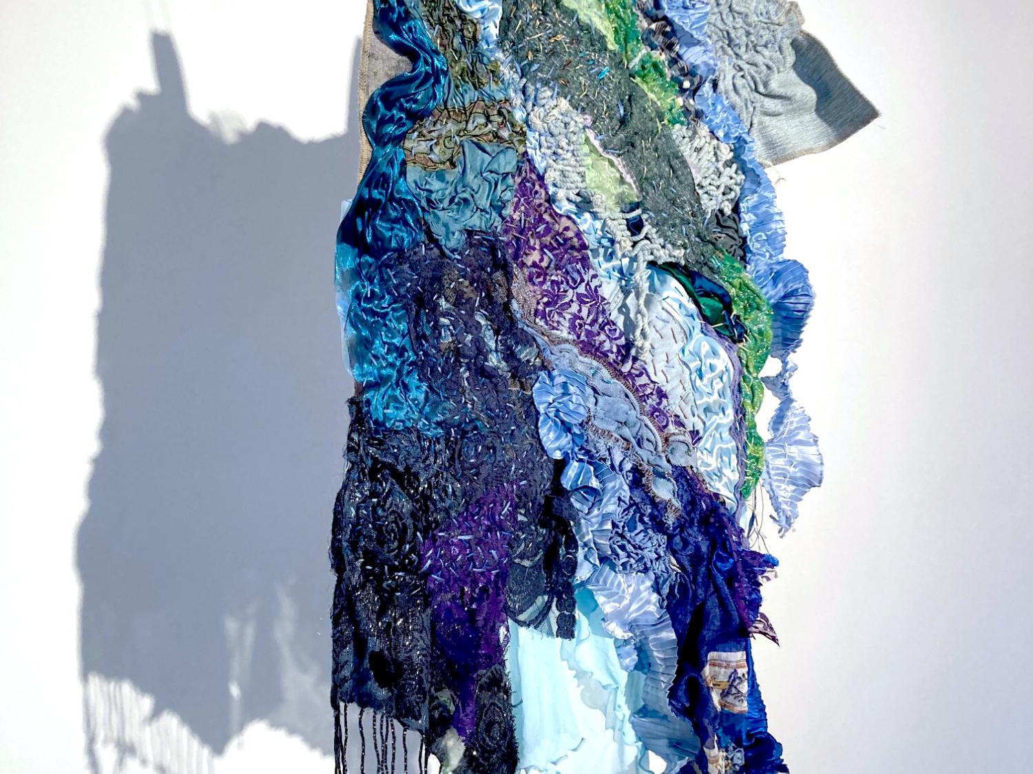Hand-stitched hanging fabric in shades of blue and green