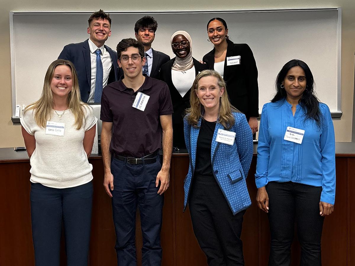 Four judges for the Dell Case Competition pose with four of the five students from the winning team