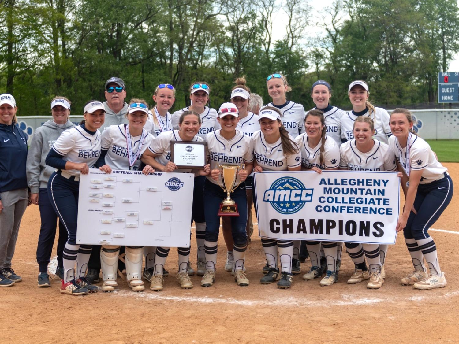The Penn State Behrend softball team poses with the AMCC championship banner.
