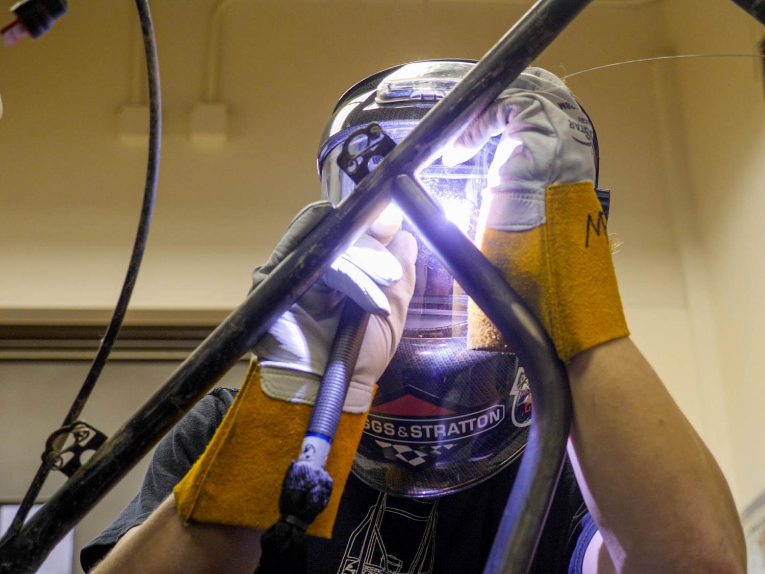 A student welding a frame