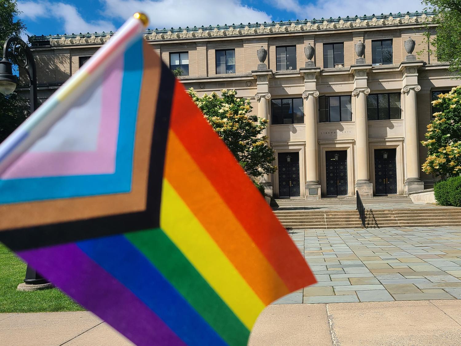 A rainbow flag is positioned against the backdrop of Sparks Building. 