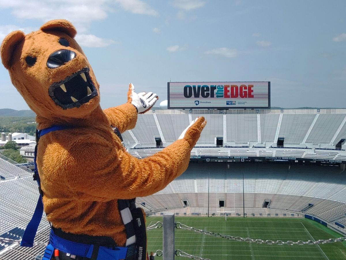 The Nittany Lion mascot gestures toward a video board at Beaver Stadium