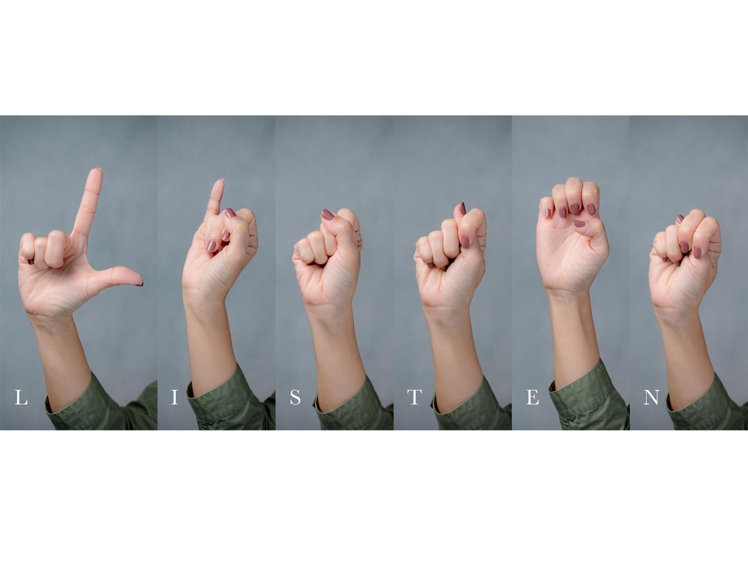 Hands gesturing using sign language to spell the word “listen”.