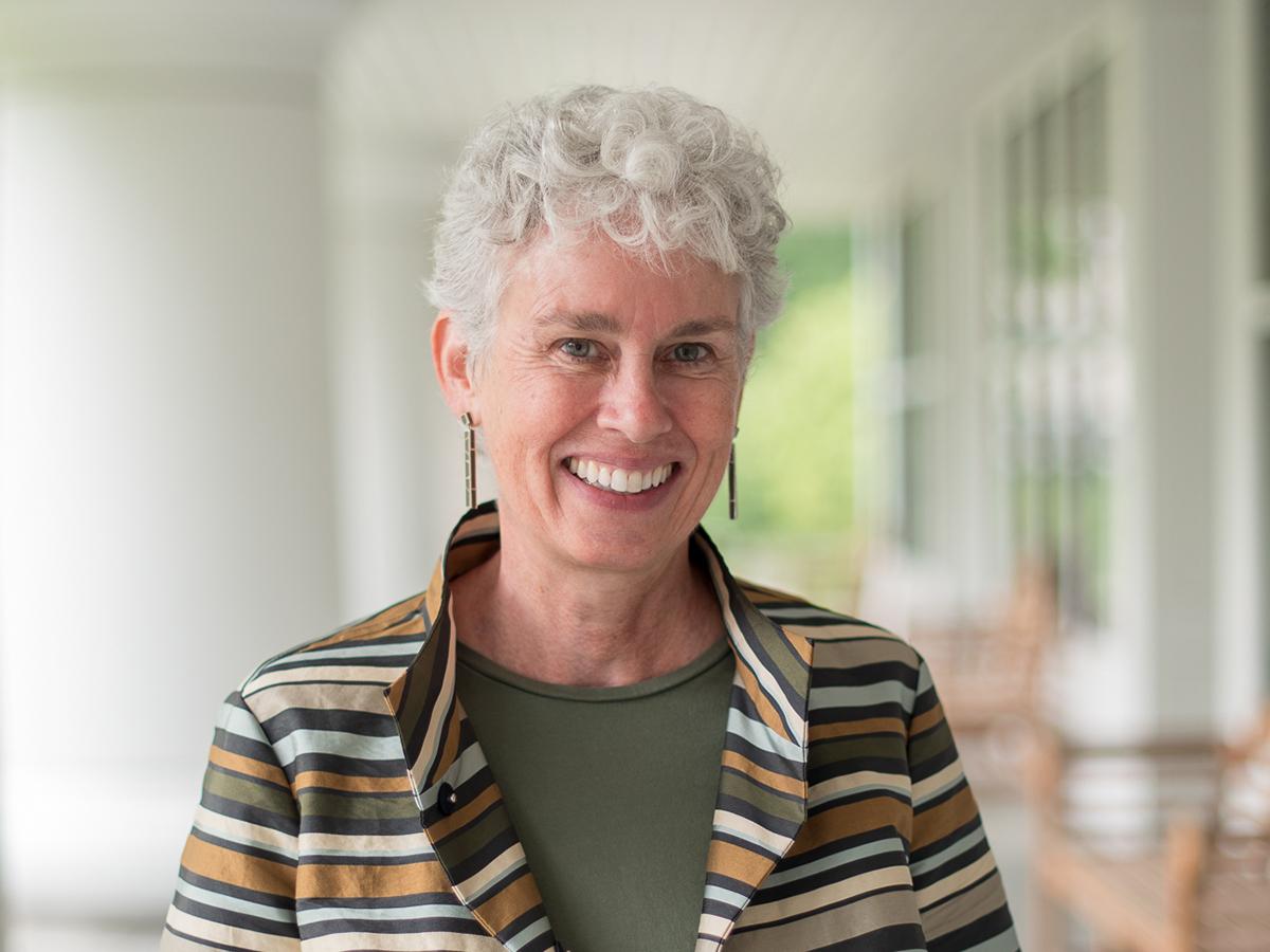 Smiling woman with a green shirt and striped blazer