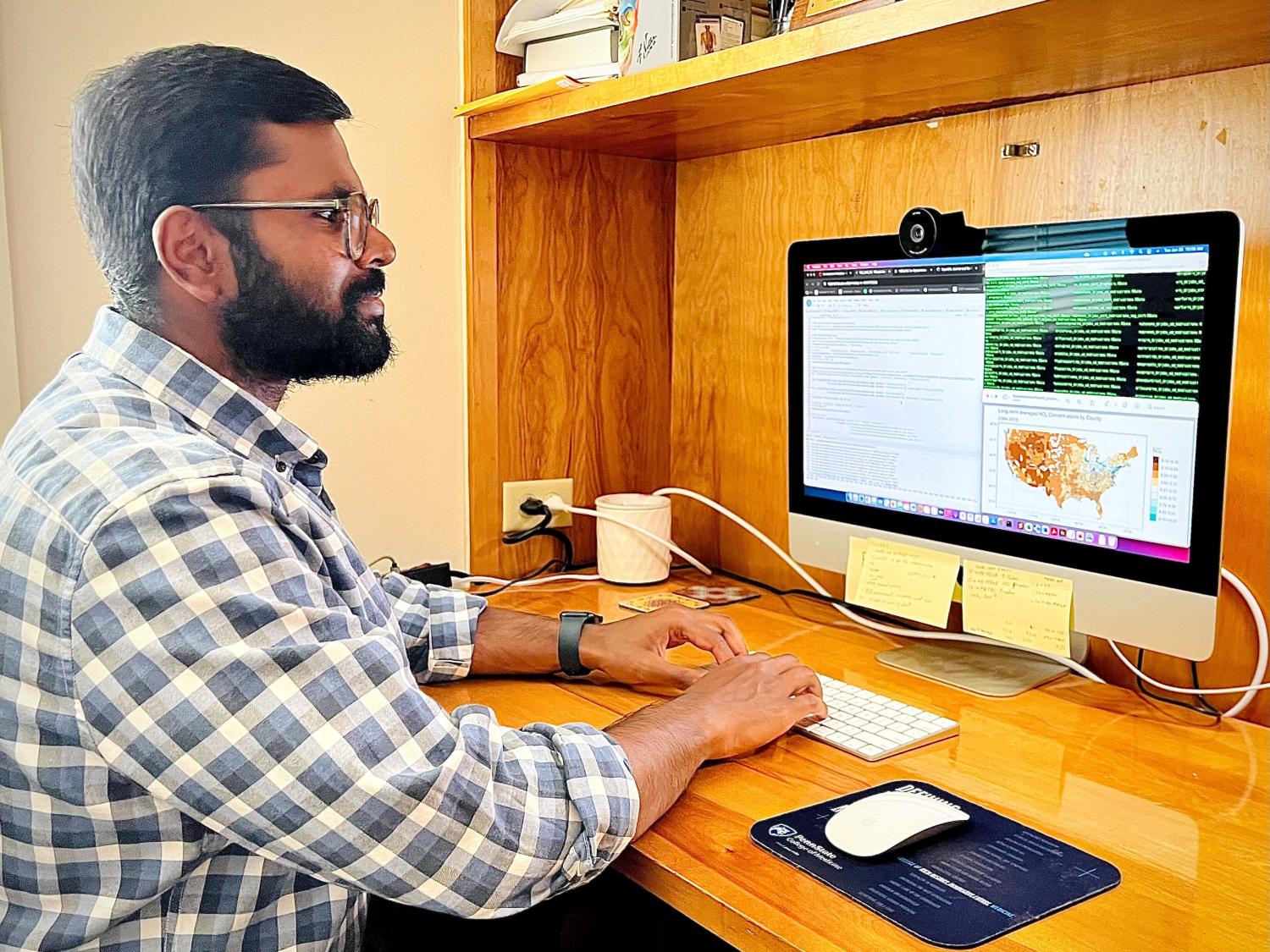 Research scientist sitting at a desk and looking at data sets on a computer