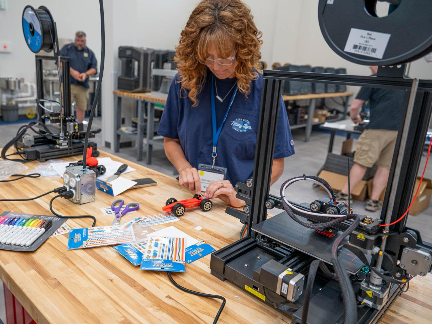 A person works on a mini-car made by a three D printer