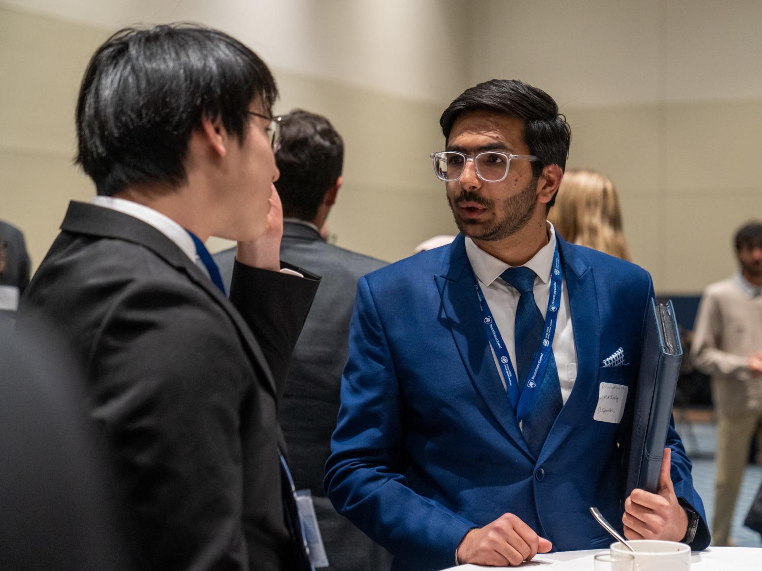 Two young men in suits talking to each other